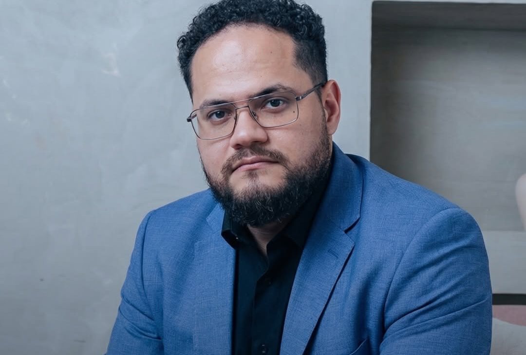 Retrato de Fernando Junior de blazer e óculos
